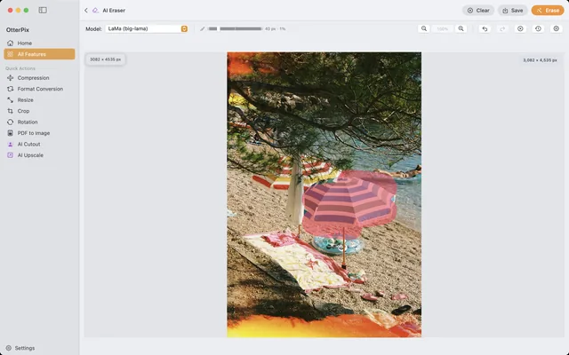 The OtterPix AI Eraser on macOS: a striped beach parasol painted over with the red brush mask, ready for the Erase button to fill the spot with background.